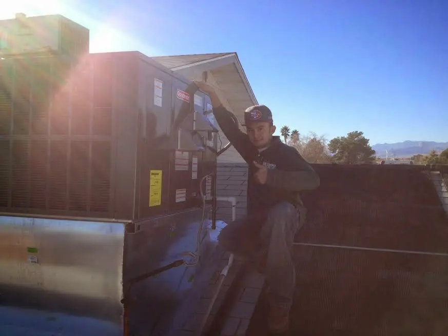 HVAC technician performing HVAC Inspection on a rooftop unit in Ottumwa